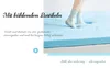 A person's feet in socks are shown pressing into a light blue foam mattress. Produktbild-Vorschau
