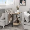 A side table next to a couch with a blanket and a vase of flowers. Produktbild-Vorschau