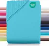 A folded turquoise fitted sheet is displayed with a stack of other colored sheets in the background. Produktbild-Vorschau