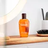 A bottle of Tabac Original Shower Gel is placed on a wooden shelf in front of a mirror. Podgląd zdjęcia produktu