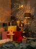 A collection of decorative lamps displayed in a room with a tropical-themed wallpaper and various colored blocks. Podgląd zdjęcia produktu
