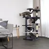 Three cats are playing on a multi-level cat tree in a living room setting. Náhled obrázku produktu
