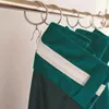 Close-up of green curtains hanging on a rod with rings. Produktbild-Vorschau