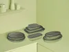 A collection of glass food storage containers with gray lids are arranged on a light green countertop. Náhled obrázku produktu