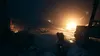 A dark, atmospheric scene with a fire burning in the background, and a hand holding a pistol in the foreground. Náhľad obrázku produktu