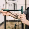 A person's hands are holding a green and black garden structure, possibly part of a greenhouse frame. Produktbild-Vorschau