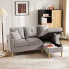 A light gray sectional sofa with its storage compartment open, revealing blankets and pillows inside. The sofa is in a living room setting with a floor lamp and a cabinet in the background. Náhľad obrázku produktu