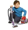A young boy is playing with a toy vacuum cleaner. Produktbild-Vorschau