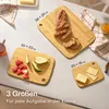 Three bamboo cutting boards of different sizes are arranged on a table, with food items like bread, strawberries, pears, and cheese on them. Text overlays indicate sizes and a slogan. Anteprima dell’immagine prodotto