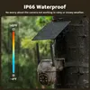 A security camera with a solar panel attached to a tree in a rainy outdoor environment. Produktbild-Vorschau
