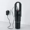 A black handheld vacuum cleaner is plugged into a white wall socket for charging. Podgląd zdjęcia produktu