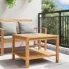 A wooden coffee table and bench on a balcony with greenery and a railing. Náhled obrázku produktu