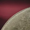 A close-up view of the edge of a khaki-colored fabric seat with a black frame, set against a dark red background. Produktbild-Vorschau