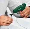 A person is using a green and red glue gun to apply hot glue to a black suction cup attached to a metal rod. Produktbild-Vorschau