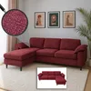 A sectional sofa in a living room setting with artwork on the wall and a plant.