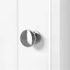 A close-up shot of a silver doorknob on a white cabinet door. Produktbild-Vorschau