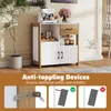 A modern kitchen cabinet with a coffee machine and flowers on top, shown in a room setting. The bottom part of the image displays anti-toppling devices. Podgląd zdjęcia produktu