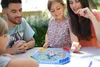 A family playing a board game outdoors. Náhľad obrázku produktu