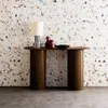 A console table with a lamp and decorative items against a terrazzo-patterned wall. Produktbild-Vorschau