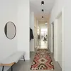 A modern hallway with a bench, mirror, and a patterned rug. Anteprima dell’immagine prodotto