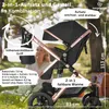 A woman is sitting in the background behind a stroller, with trees and grass visible. Produktbild-Vorschau