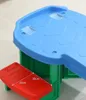 A close-up view of a children's play table and a red step stool, with dimensions indicated on the stool. Voir les images du produit