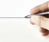 A hand holding a rotring Tikky Graphic pen, drawing a thin black line on a white surface. Anteprima dell’immagine prodotto
