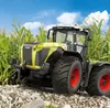 A yellow and black tractor is parked in a field of tall green corn under a blue sky with white clouds. Produktbild-Vorschau