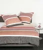 A neatly made bed with striped bedding and two pillows. Produktbild-Vorschau
