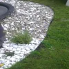 A garden bed border made of metal, separating gravel and grass. Produktbild-Vorschau