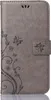 A gray flip phone case with a floral and butterfly embossed design. Produktbild-Vorschau