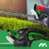 A person is using a hedge trimmer to cut a bush, with leaves flying around. Náhľad obrázku produktu