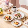 A table setting with plates of food, drinks, and a cupcake, suggesting a meal or gathering. Voir les images du produit