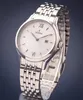 A close-up studio shot of a silver Festina watch with a white dial, set against a dark gray background. Náhľad obrázku produktu