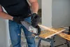A person is using an angle grinder to cut metal, with sparks flying. Produktbild-Vorschau