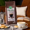 A bag of coffee beans, a moka pot, a cup of coffee, and cookies are arranged on a table, suggesting a cozy coffee break. Náhľad obrázku produktu
