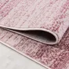 A close-up view of a pink rug with a distressed pattern, showing the texture and the rolled edge. Podgląd zdjęcia produktu