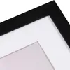 A close-up view of a black picture frame with a white mat. Produktbild-Vorschau
