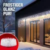 A house exterior at night, decorated with icicle lights. Produktbild-Vorschau