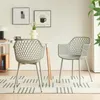 Two gray chairs are placed on a rug in front of a table with artwork on the wall. Náhled obrázku produktu