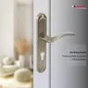A close-up of a bronze-colored door handle on a white door, with a blurred background of a room interior. Text overlays provide product information. Produktbild-Vorschau