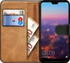 A brown leather book-style phone case is open, showing cards and cash inserted, with a Huawei P20 Pro phone displaying a colorful cityscape at dusk. Anteprima dell’immagine prodotto