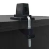 A black clamp is attached to the edge of a dark wooden table. Náhľad obrázku produktu