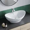 A white ceramic vessel sink with a chrome faucet is shown on a dark countertop with green tiled backsplash. Produktbild-Vorschau