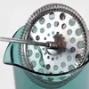 A close-up view of the plunger and filter mechanism of a French press coffee or tea maker, resting inside the teal glass carafe. Produktbild-Vorschau