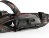 Close-up view of a black headlamp with a black and orange patterned strap. Podgląd zdjęcia produktu