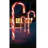 Christmas candy cane garden lights in the snow at night, with a house in the background. Produktbild-Vorschau