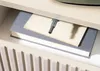 A close-up view of a nightstand with books and a small object resembling a gun on top. Produktbild-Vorschau