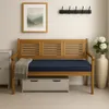 A wooden bench with a blue cushion and a gray blanket, placed in a room with a framed picture on the wall and a vase with flowers. Produktbild-Vorschau