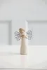 A small angel figurine with wire wings stands on a white surface against a white background. Produktbild-Vorschau